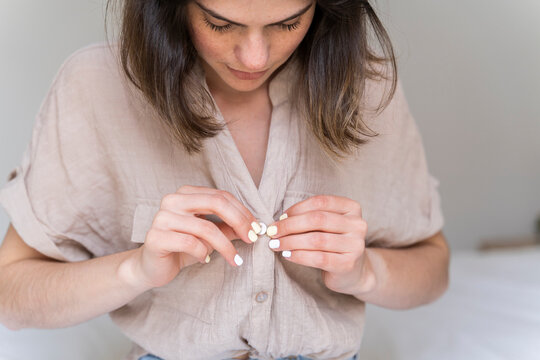 Young woman buttoning her shirt