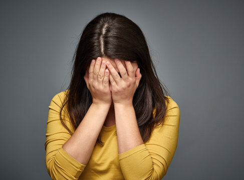 Unhappy young woman covering her face