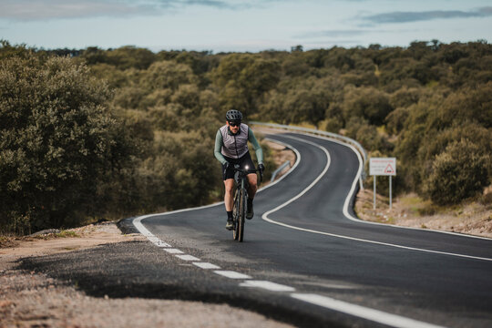Cyclist wearing cycling helmet riding bicycle on road