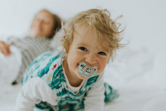 Portrait of happy little girl with mother in bed