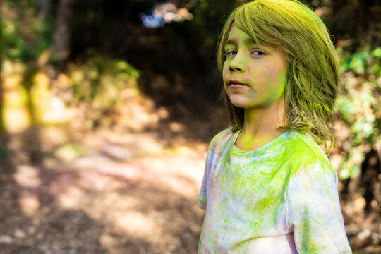 Boy full of colorful powder paint, celebrating Holi, Festival of Colors