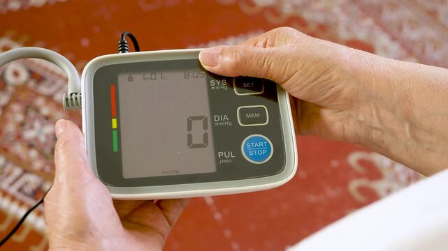Close Up of Senior Woman Measuring Blood Pressure With Digital Monitor