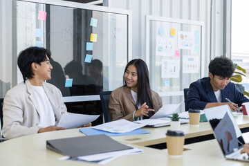 Fototapeta premium Asian business team having happy meeting in modern office space smiling cheerful professional colleague discussing over document improving good communication