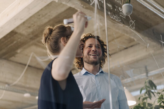 Smiling businessman and businesswoman working on a project in office