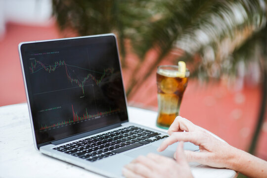 Woman trading cryptocurrency on laptop at bar
