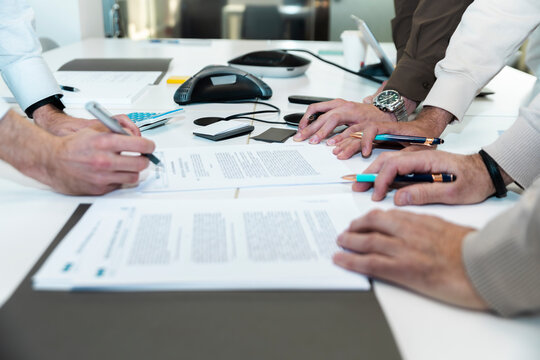 Businessmen analyze a project document at the office table