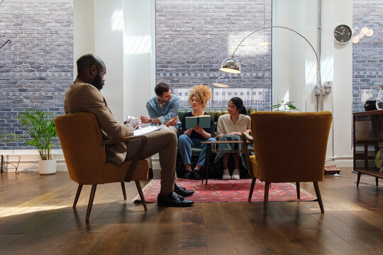 Business people sitting in modern coworking space brainstorming together