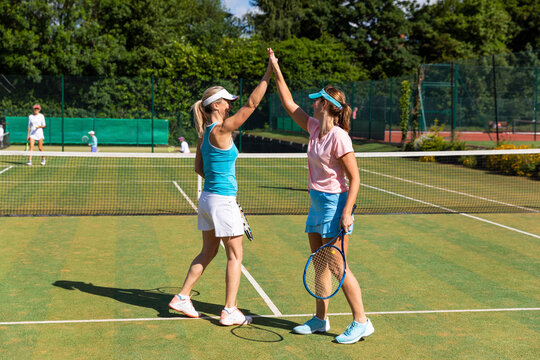 Happy mature women celebrating after tennis match