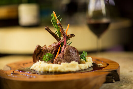 Garnished lamb chop on wooden serving plate
