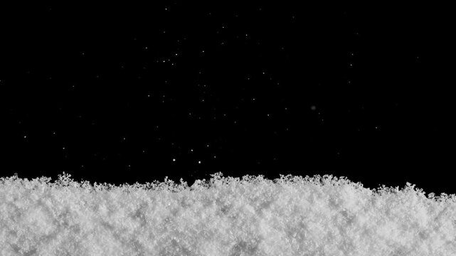 Snow falls on a wooden floor with a pile of snow