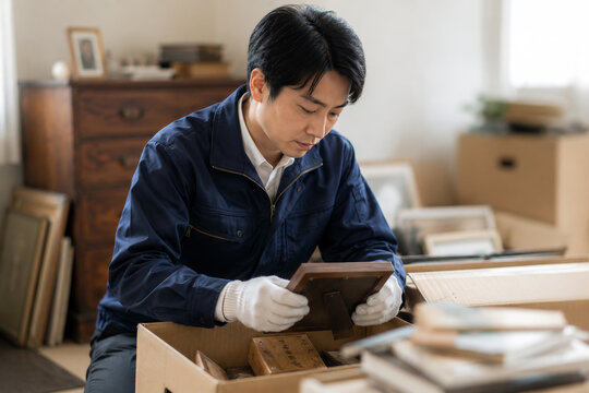 遺品整理　写真立てを整理する専門スタッフ