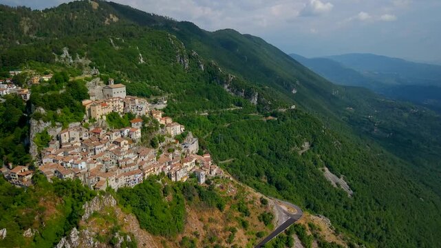 Cervara di Roma drone cinematic flight over the historic cliffside borgo, cascading stone houses and old church nestled in green mountains of Lazio, Italy
