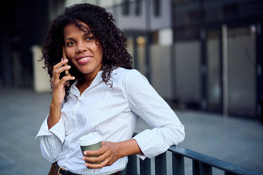 Confident African American Businesswoman On Phone With Coffee In Urban Office District For Professional Branding