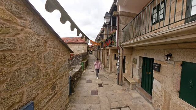 Person walking through the historic cobblestone street of Combarro, Pontevedra, Galicia, Spain
