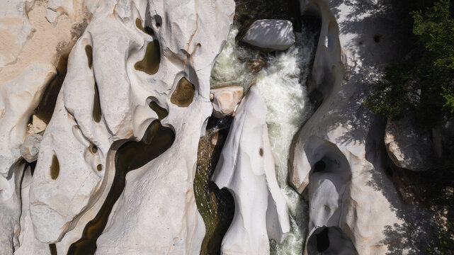 Aerial view of water flowing through sculpted canyon rocks