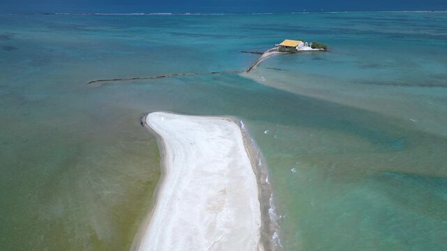 Aerial view of a sandbar and an islet with a chapel in the sea