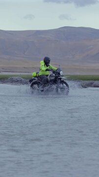 Vertical Shot of Adventure Motorcyclist Crossing River in Ladakh, India