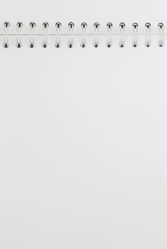 blank page of opened sketchbook with metallic spiral binder