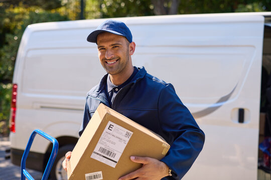 Smiling delivery man holding parcel