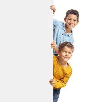 Kids peeking from behind a blank white board