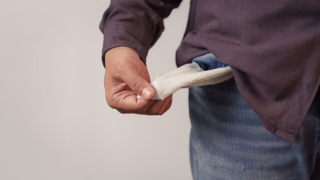 Adult man showing empty pocket indicating he is broke and has no money. Financial crisis, debt, poor, lose a job and bankrupt business concept.
