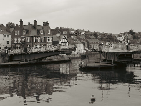 Historic Swing Bridge and Waterfront Buildings in Whitby, North Yorkshire, England, Monochrome Harbour Scene with Reflections and Traditional Coastal Architecture