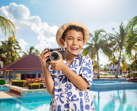 Cheerful boy tourist taking a photo with a vintage camera