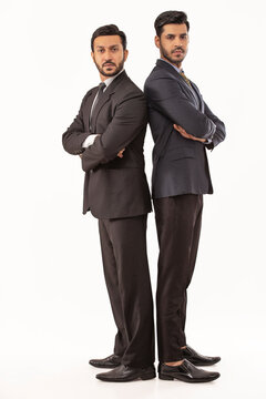Two corporate employees in formal business suit Standing back to back adjacently against white background.