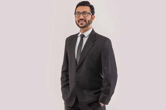 Portrait of a corporate employee in formal business suit standing with hands in pocket.