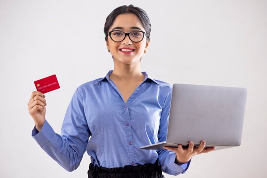 Young girl shopping online through laptop using credit card