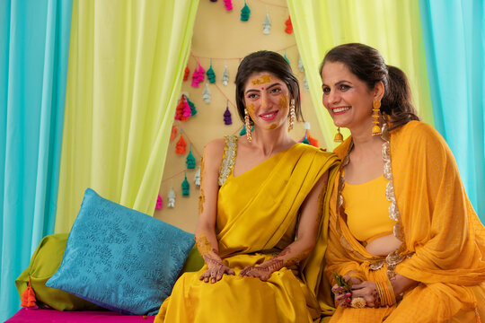 Portrait of Mother and daughter sitting together during haldi ceremony