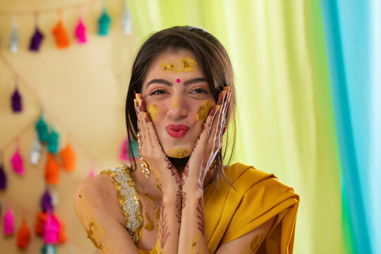 Close-up portrait of an Indian bride with turmeric applied on face