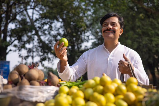 Man in white kurta shopping lemon in market