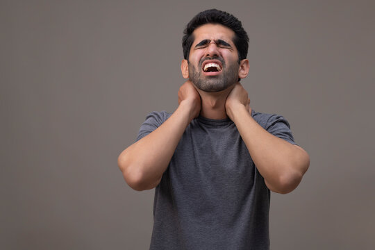 Portrait of a young man suffering from neck pain