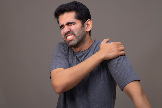 Portrait of a young man suffering from shoulder pain