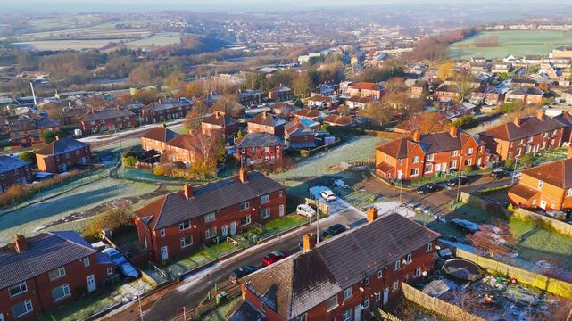 Drone's-eye winter view captures Dewsbury Moore Council estate's typical UK urban council-owned housing development with red-brick terraced homes and the industrial Yorkshire. Working class housing