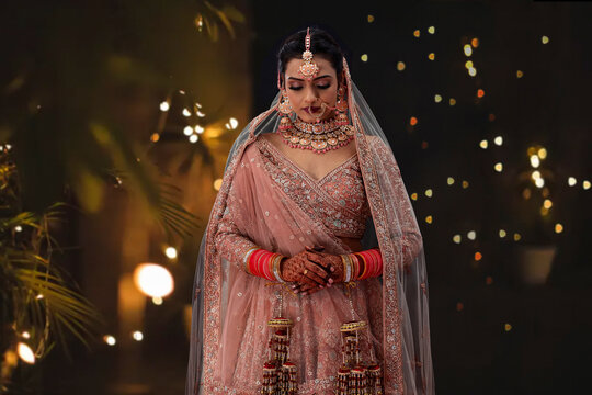Indian woman in traditional wedding outfit standing in front of camera