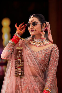 Beautiful Indian bride wearing sunglass during wedding ceremony