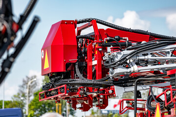 Agricultural field sprayer folded boom mechanism for pesticide application. Modern crop protection machinery frame assembly with hydraulic hoses and farming transport equipment technical detail. © NastyaPhoto