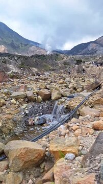 Steaming geothermal landscape at Mount Papandayan with rocky volcanic terrain.
