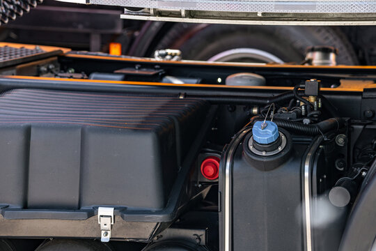 Semi truck AdBlue urea tank with blue cap on chassis assembly. Heavy duty commercial transport vehicle battery box component with frame and long haul dremtruck mechanism technical details.