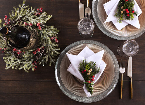Festive New Year's table setting for two. A bottle of wine. Beautiful plates on the table. Concept for a family dinner on Christmas or Thanksgiving. Top view