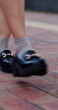 Legs, student or walking with shoes in city street for school fashion, clothing or style. Person, academic learner or travel with sneakers on sidewalk for learning journey or dress code in urban town