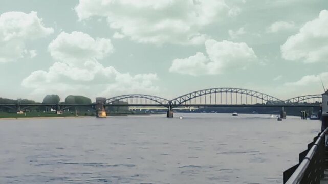 View of Cologne embankment and bridge on a clear day with clouds above the river