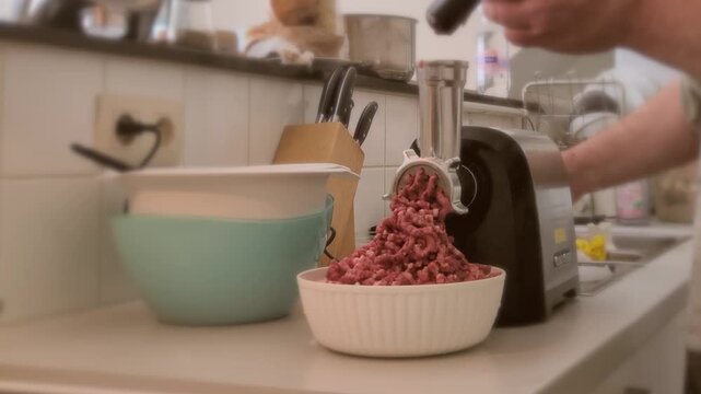 Making ground meat at home with an electric meat grinder in the kitchen