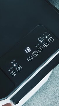 Control panel operation of floor standing room air conditioner during summer afternoon