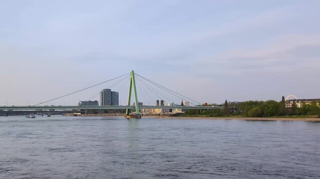 Explore the large bridge in Prison over the Rainy River at sunset with boats passing by