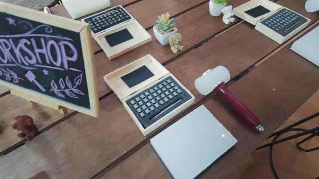 Leathercraft workshop table with alphabet stamping tools, mallet and chalkboard sign, Handmade crafting workspace with leather embossing kit, wooden workbench and DIY artisan equipment 4k
