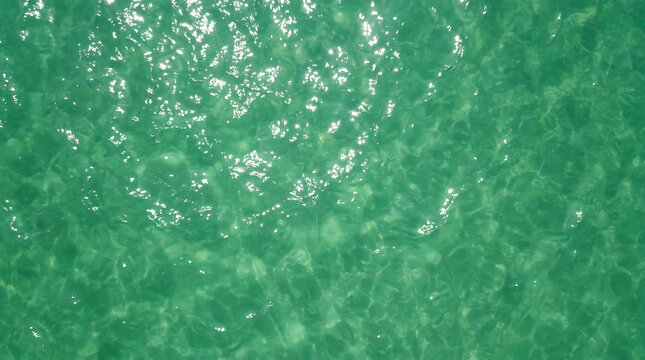 Close-up view of clear turquoise water with sunlight reflecting on the rippling surface.