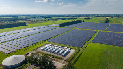 Aerial view of a large-scale solar farm featuring extensive rows of photovoltaic panels and a battery energy storage system in the rural landscape of Wanneperveen, Overijssel, Netherlands. © Ewout Pahud